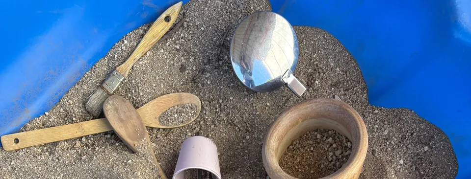 Bandeja de arena con lupa, pincel y cuencos para explorar en el aula